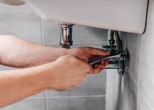 plumber repairing leaky sink